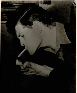 Press photograph of Tomaselli Macho lighting a cigarette with his foot