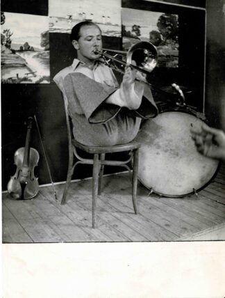 Press photograph of a man playing the trombone with his feet