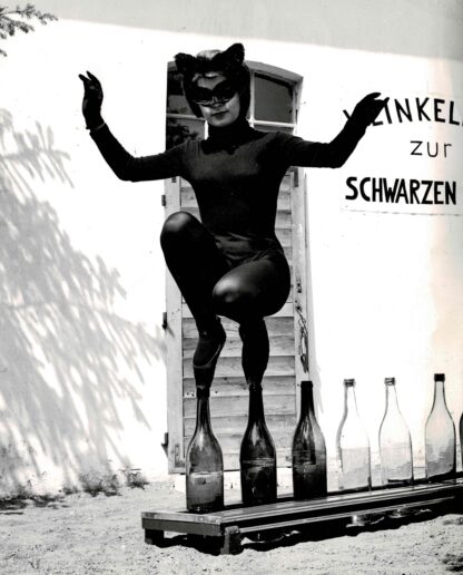 Three press photographs of a lady in a black cat suit walking on glass bottles - Image 2