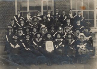 A large group of dressed up kids holding rolled up prints - undated