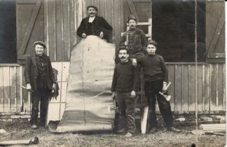 Five men posing with one holding a rolled out piece of sheet metal - undated