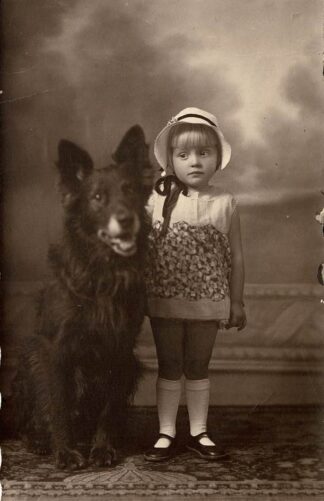Girlgirl posing with a dog of the same size. - undated.