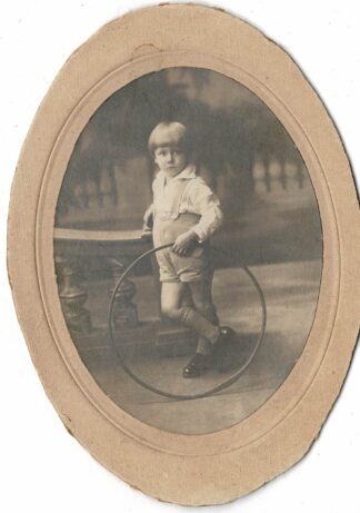 Oval photograph of a boy holding a hoop - undated