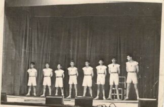 Young gymnasts posing on stage.